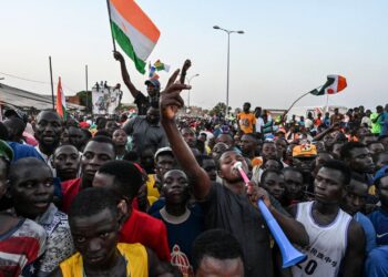 أنصار المجلس الوطني في النيجر لحماية الوطن أثناء حضورهم حفل دعم الجيش أمام القاعدة الجوية النيجرية والفرنسية في نيامي (أ.ف.ب)