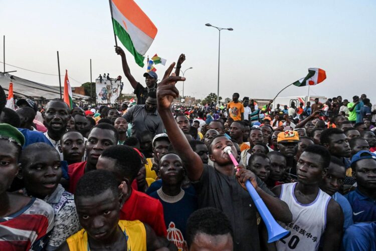 أنصار المجلس الوطني في النيجر لحماية الوطن أثناء حضورهم حفل دعم الجيش أمام القاعدة الجوية النيجرية والفرنسية في نيامي (أ.ف.ب)